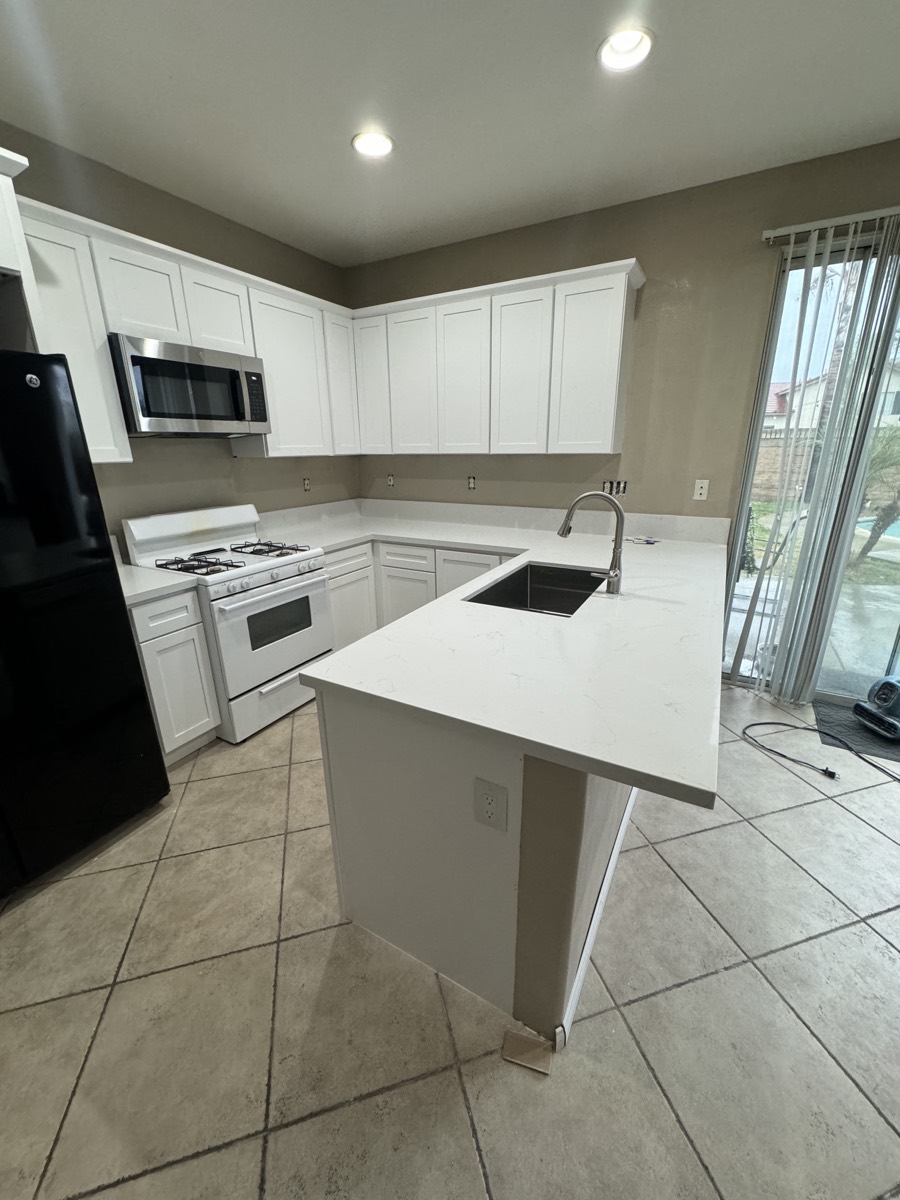 Custom white kitchen remodel with quartz peninsula