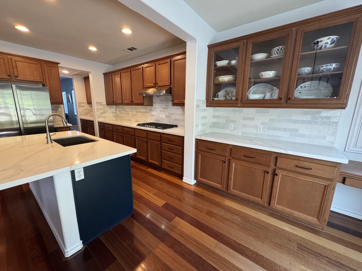 Chef's kitchen with wood cabinetry and glass display