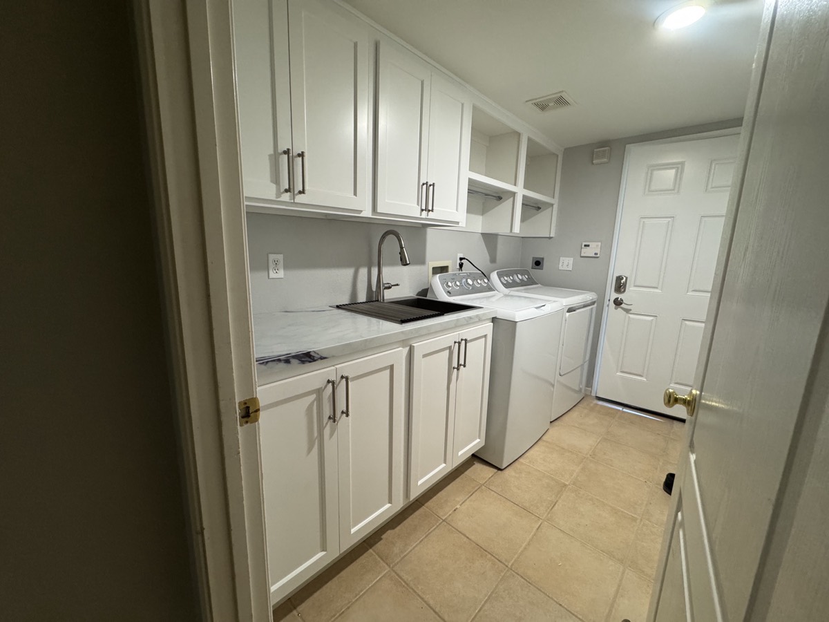 Custom laundry room with cabinetry and sink