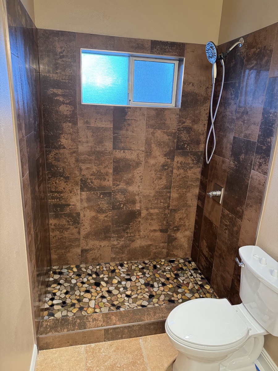 Custom tile walk-in shower with pebble floor