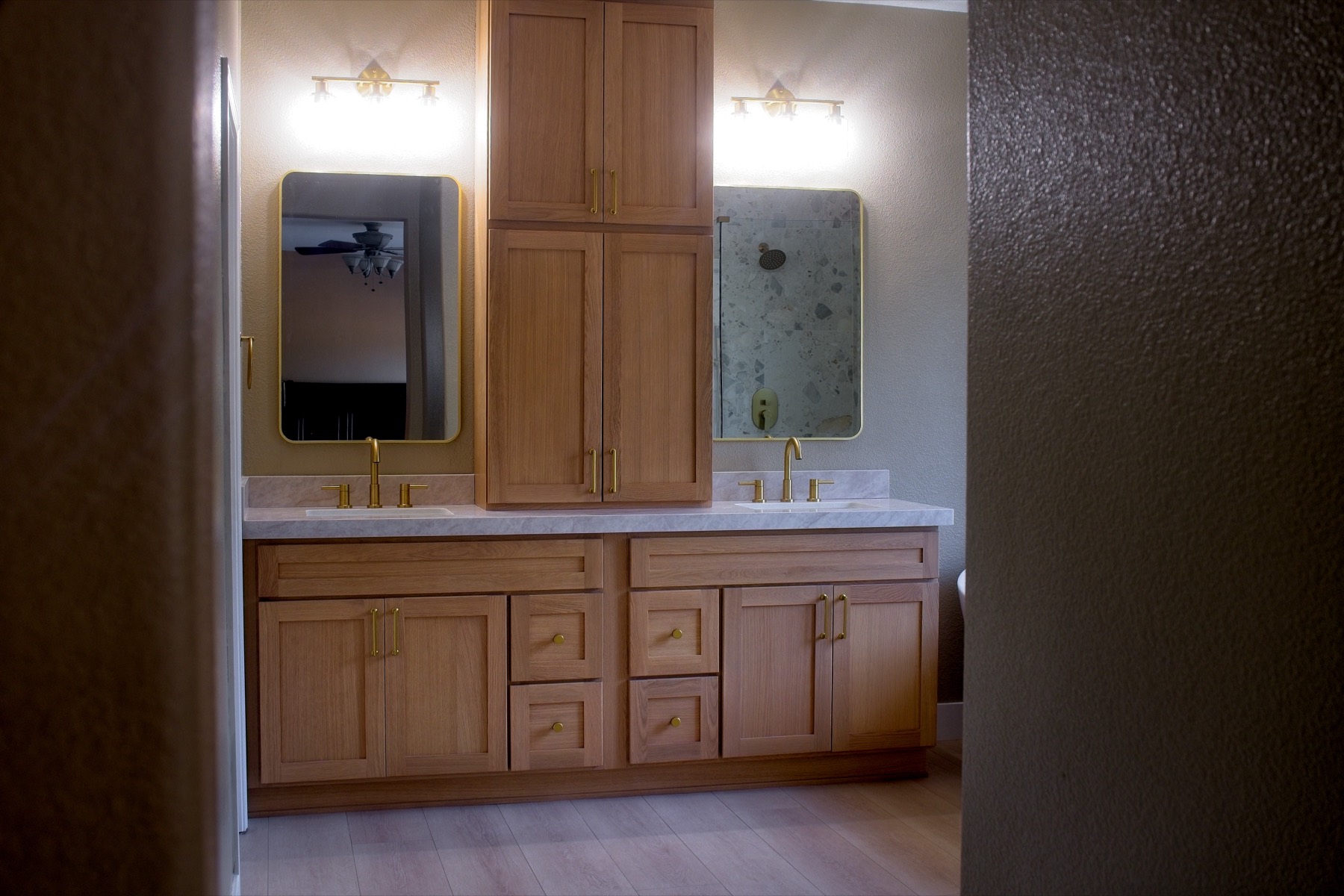 Double vanity with center tower and brass mirrors